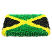 In this photograph, a funeral tribute inspired by the Jamaican flag has been recreated as a striking floral panel, rectangular and full of depth, set starkly against a bright white background that makes every colour sing. A bold golden yellow saltire forms an X from corner to corner, each line built from clusters of small, ruffled yellow flowers whose layered petals create a soft, tactile surface reminiscent of sunshine captured in bloom form. This cross separates the tribute into four strong triangles. The top and bottom are carpeted with rich green flowers and foliage, so densely arranged that the area looks like a lush, living tapestry, hinting at the freshness you'd notice if you stood close enough to breathe in the scent. On the left and right, triangular sections of deep black blooms and dark, petal-like material anchor the design; their matte, velvety texture adds solemnity and balance to the vivid green and yellow. The lighting is clear and evenly spread, which highlights the tiny creases, folds, and shadowed pockets between petals, emphasizing the piece's handcrafted character. The arrangement appears thick and substantial, the sort of carefully constructed tribute that might be delivered to a Bounds Green funeral home or chapel for a farewell steeped in Jamaican heritage. It conveys themes of strength, identity, and remembrance, reflecting the pride many local families feel in their Caribbean roots. Crafted with quiet reverence, this floral flag seems designed to stand beside a coffin or memorial display, offering comfort and a powerful visual statement of respect.