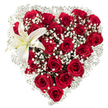A lovingly crafted heart-shaped bouquet sits against a pure white backdrop, every inch filled with deep crimson roses whose velvety petals range from tight buds to fully unfurled blooms. The roses-arranged so closely they form the sculpted contours of the heart-give the piece a dense, tactile richness; you can almost feel the soft velvet under your fingertips. Between those rich red heads, clouds of tiny white baby's breath (Gypsophila) float like soft breath, their star-like florets creating delicate negative space that brightens the composition and softens the heart's outline. Nestled into the upper left curve is a single, sculptural white lily: broad, waxy petals of pristine white with the faintest creamy-yellow wash at the throat and distinct yellow-orange stamens at its center. The lily's smooth, arching form provides an elegant focal counterpoint to the clustered roses, introducing a quiet purity and a touch of fragrant lift. The lighting is neutral and even, highlighting the deep reds and the contrast of the crisp whites while keeping shadows soft so the bouquet feels intimate and immediate. A skilled florist's hand is evident in the precise shaping and balance-each rose placed for depth, each sprig of gypsophila invited to breathe-so the arrangement reads as both luxurious and sincere. This floral heart radiates romantic intent and ceremonial grace alike: suitable for a Valentine's offering, an anniversary tribute, or a refined sympathy gesture. Imagined for delivery around Bounds Green and nearby Wood Green, it carries the calm assurance of fresh blooms picked and composed with care for local celebrations and quiet remembrances.